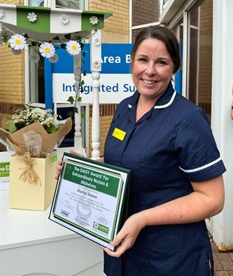 Nurse holding award outside